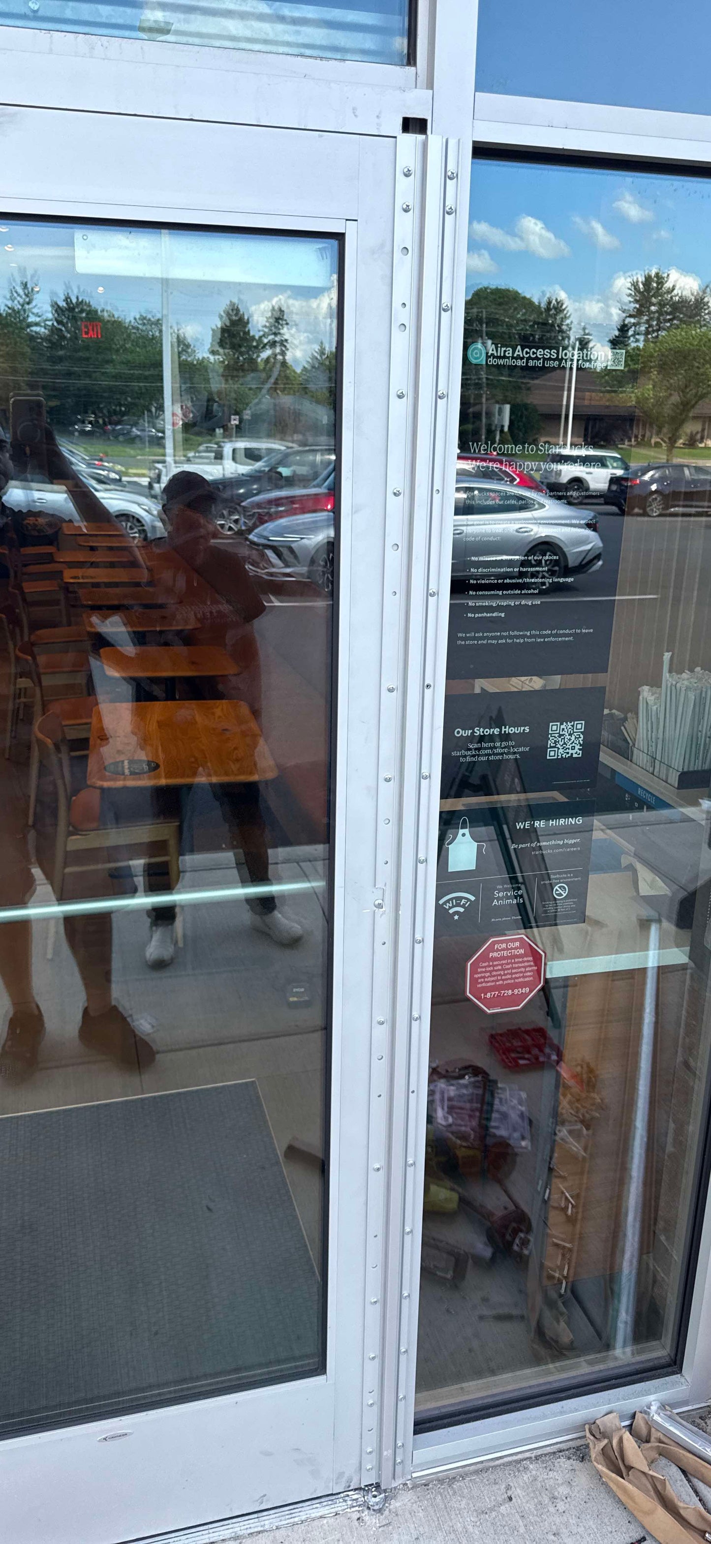 Damaged storefront entry glass at New Balance before repair
