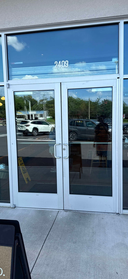 Technician performing emergency glass repair at commercial property