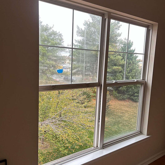 Technician replacing cracked or foggy double-pane window glass for improved energy efficiency